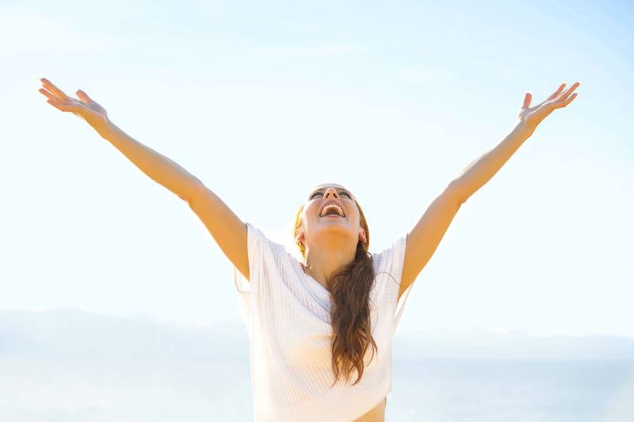 Woman spreading arms out to sky